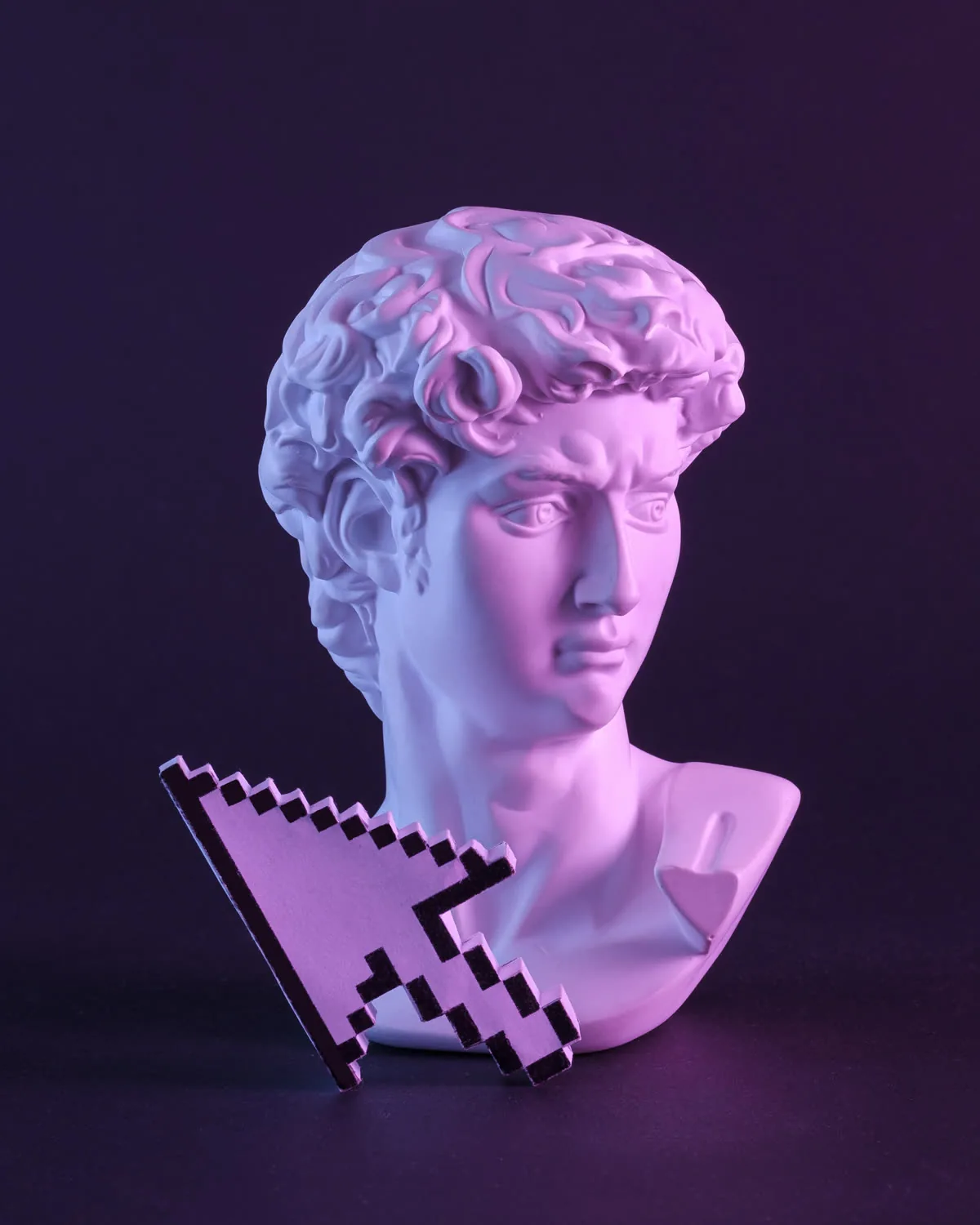 Busto in gesso illuminato di viola accanto a un cursore del mouse a pixel